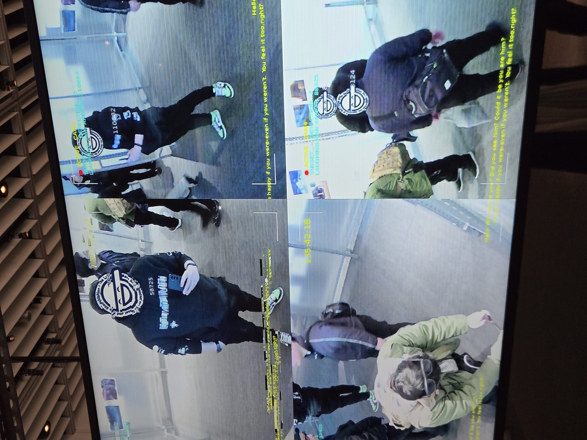 Interactive surveillance installation at Ghost in the Shell Exhibition — screens showing real-time AI tracking overlays of visitors