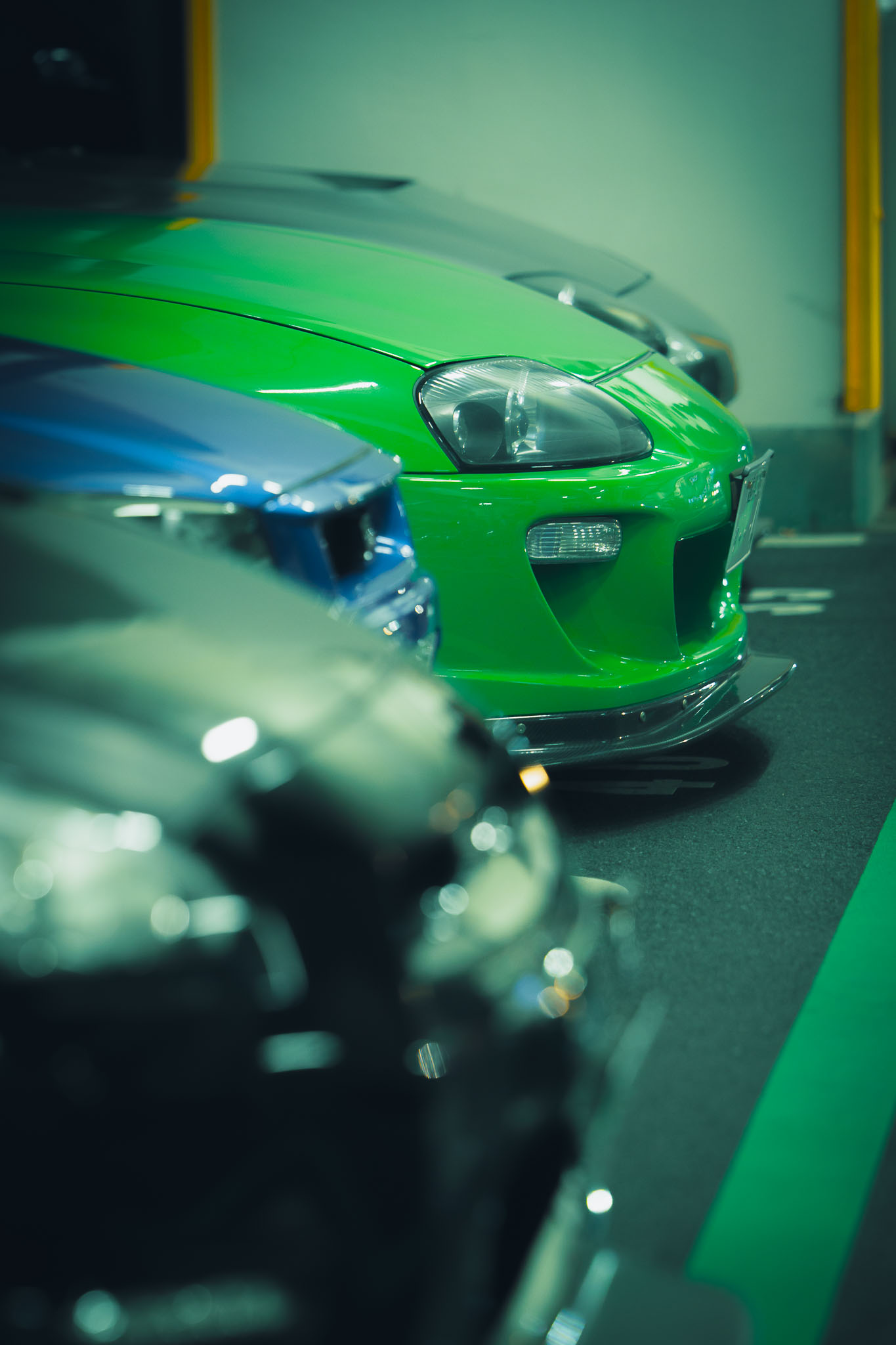 JDM cars lined up at Umi Hotaru — green Toyota Supra A80 and modified Japanese cars