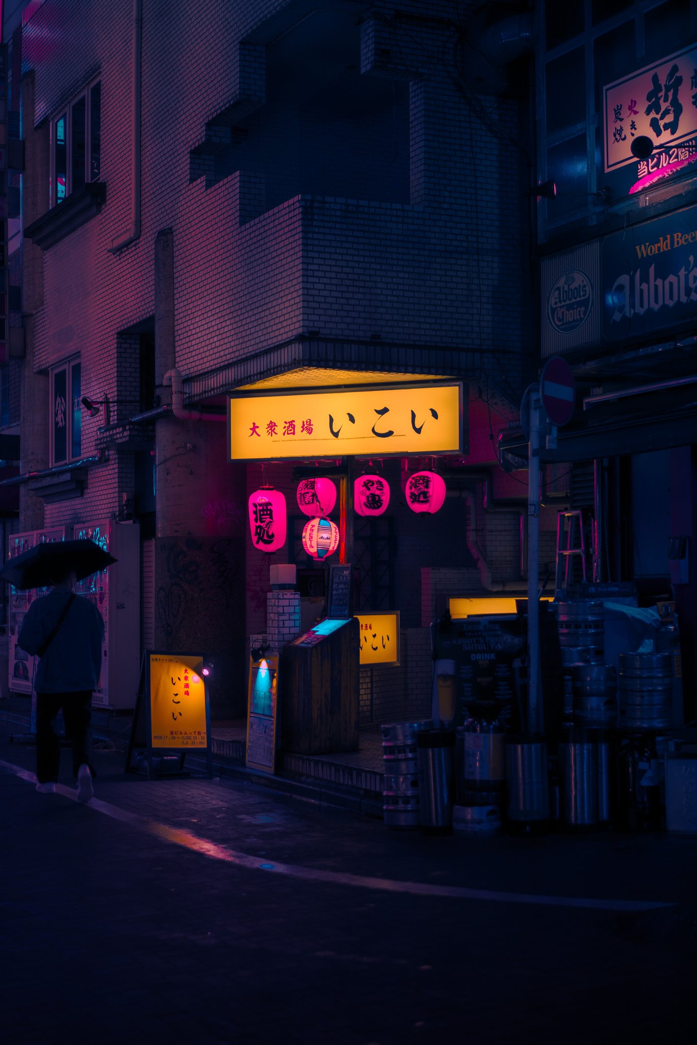 Izakaya lit up at night in the rain — pink lanterns and umbrella, Tokyo