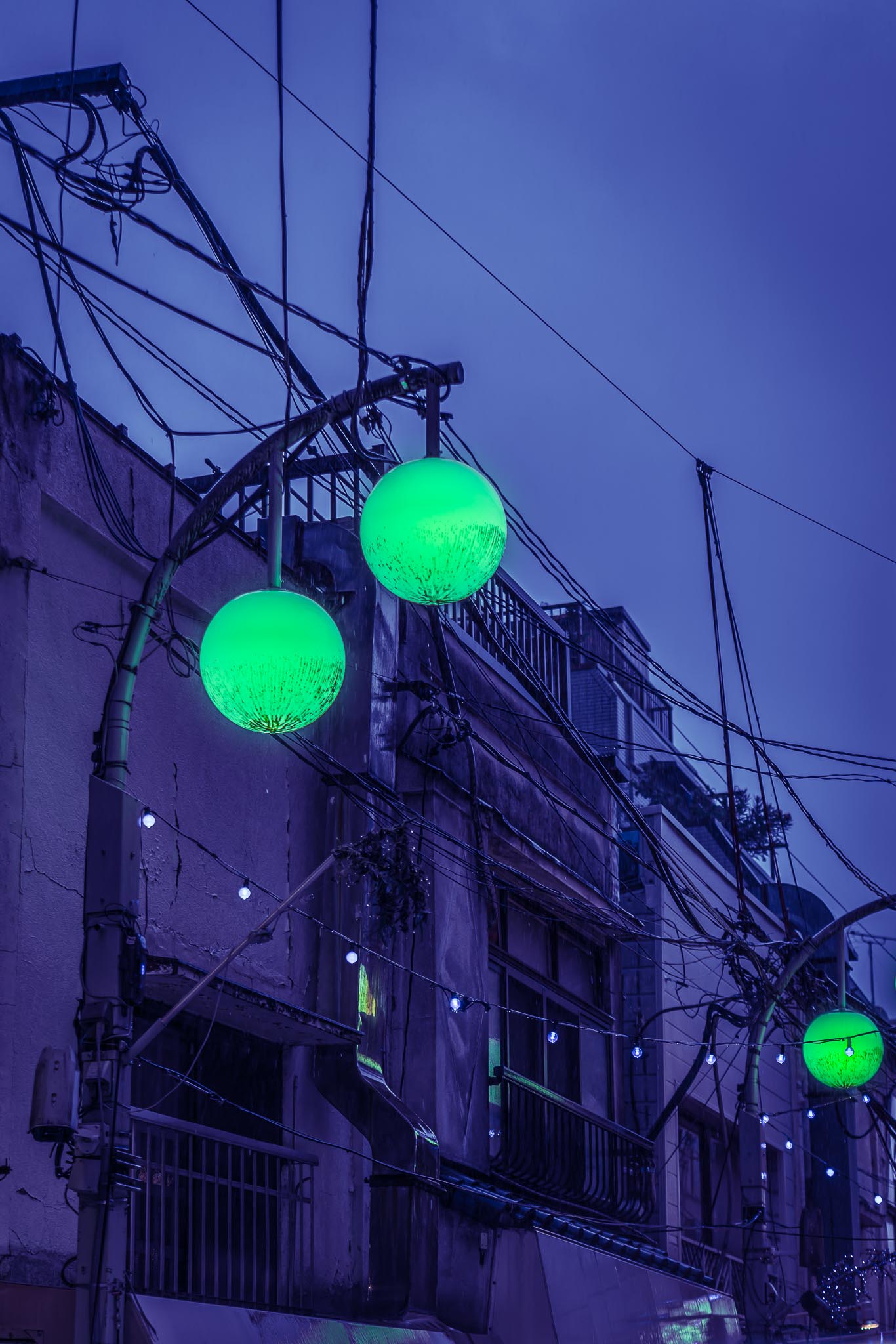 Nakano Tokyo at dusk — green glowing orb street lights against power lines