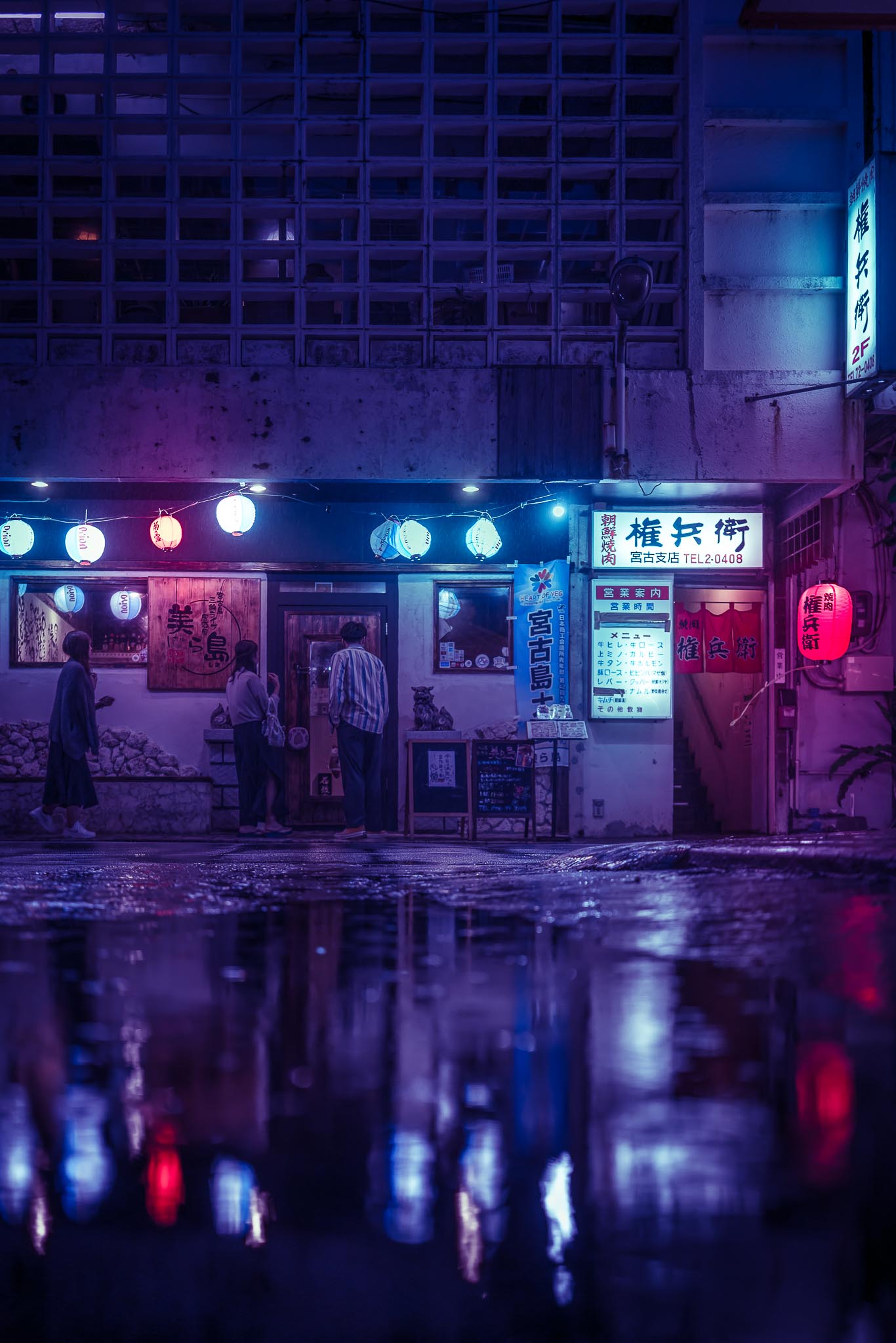 Rainy night street in Naha Okinawa — purple neon reflections and izakaya lanterns