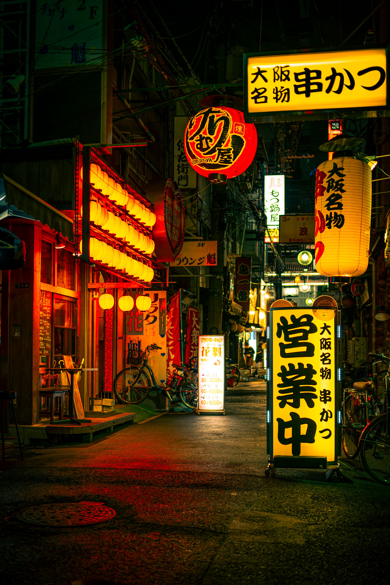 Osaka alley at night with kushikatsu signs and warm orange lanterns