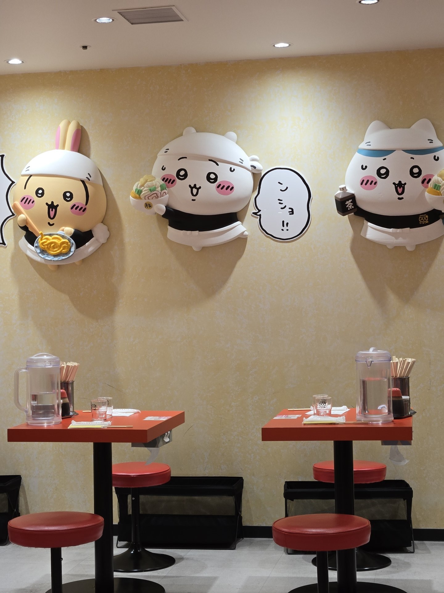 Chiikawa Ramen Ton interior dining area — red stools tables character wall decorations Ikebukuro